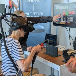 Eine Besucherin testet mithilfe einer VR-Simulation das Schweißen am Stand von TKMS.